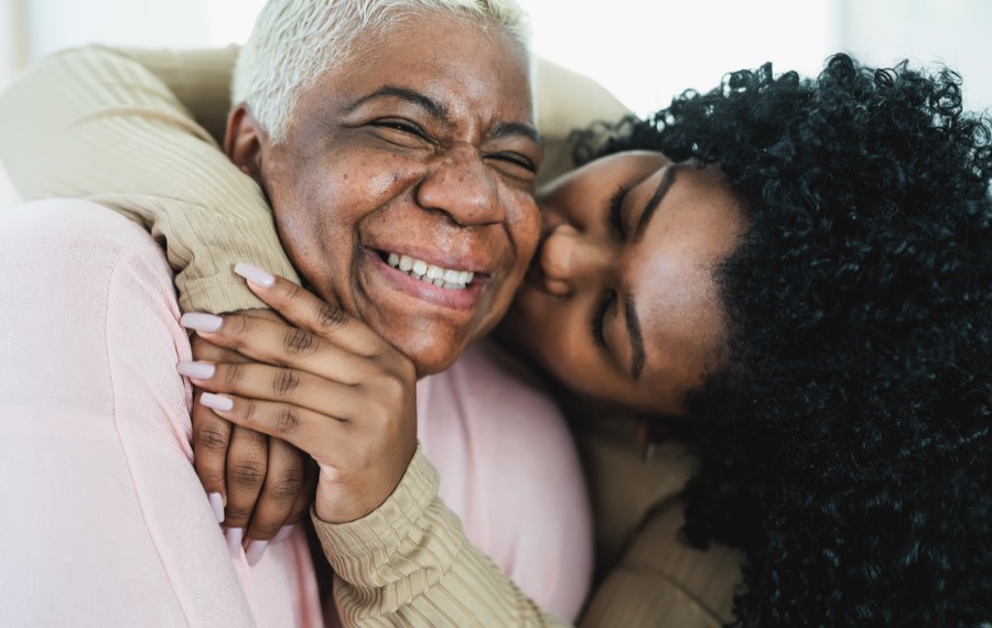A daughter joyfully embracing her smiling mother
