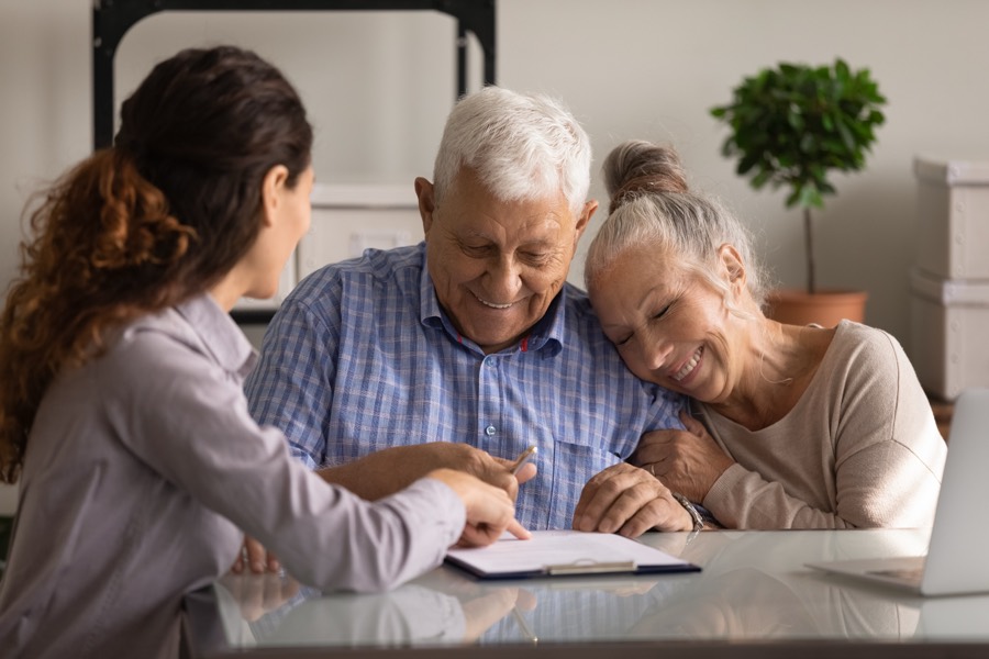 A care navigator reviewing a plan with a happy senior couple